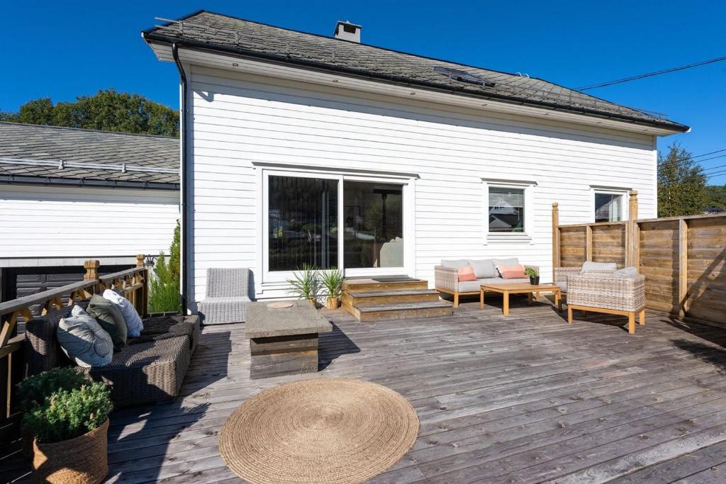 奥勒松Aalesund Holiday Home 5 Bedroom!的带家具的木制甲板和房屋