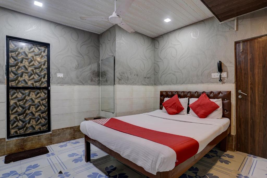 孟买OYO Flagship Hotel Sapna Residency的一间卧室配有红色枕头的床