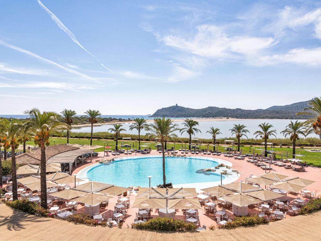 维拉西米乌斯Pullman Almar Timi Ama Resort & Spa的享有带椅子和棕榈树的度假村游泳池的空中景致