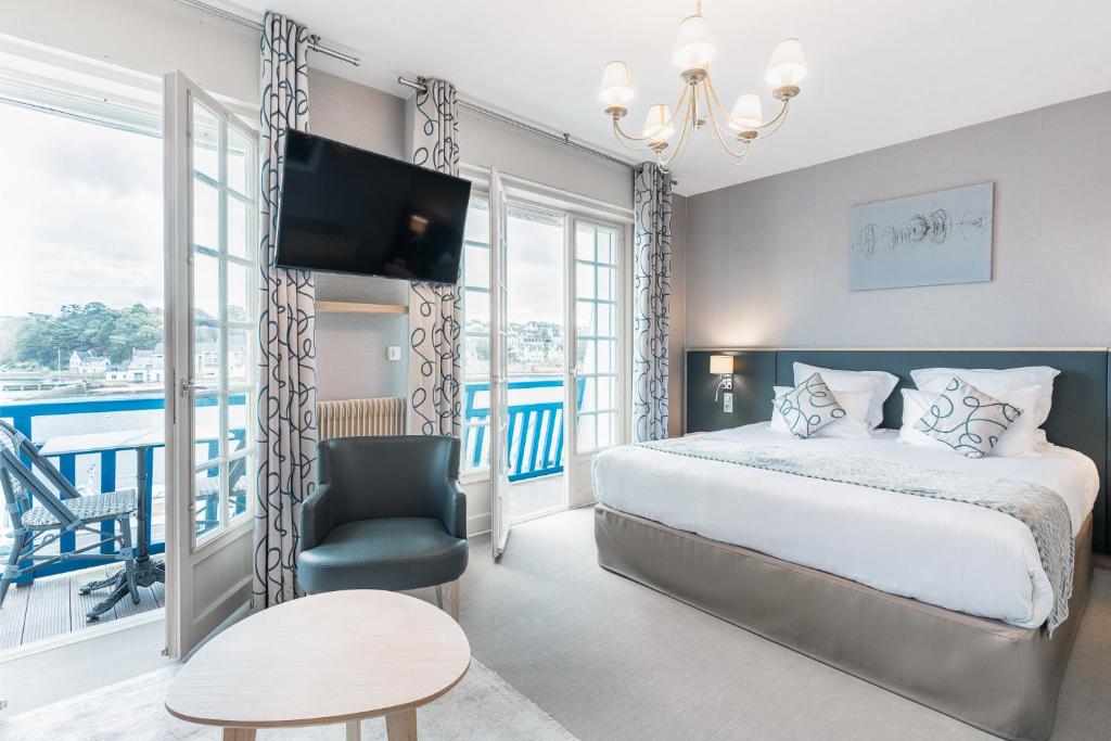 欧迪耶讷Logis hôtel restaurant Le Goyen的一间卧室配有一张床、一台电视和一把椅子