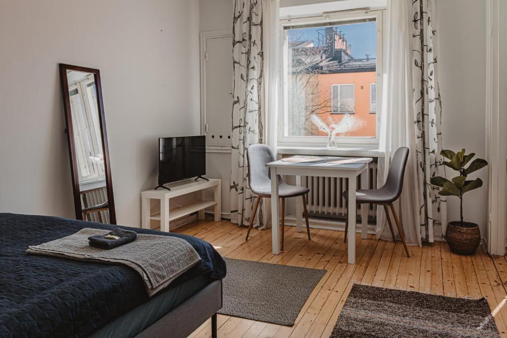赫尔辛基Nordstay - Trendy Studio by the North Harbor self check-in的一间卧室配有一张床、一张桌子和一个窗户。