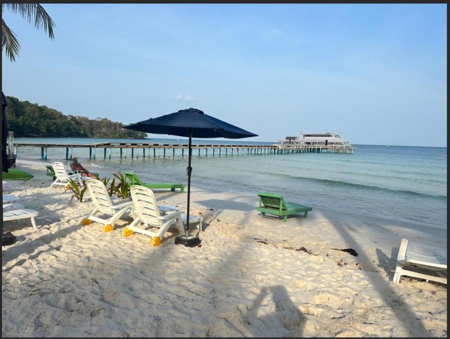 Phumĭ Kaôh RŏngKoh RhongSunshine Resort2的海滩上的一组椅子和一把遮阳伞