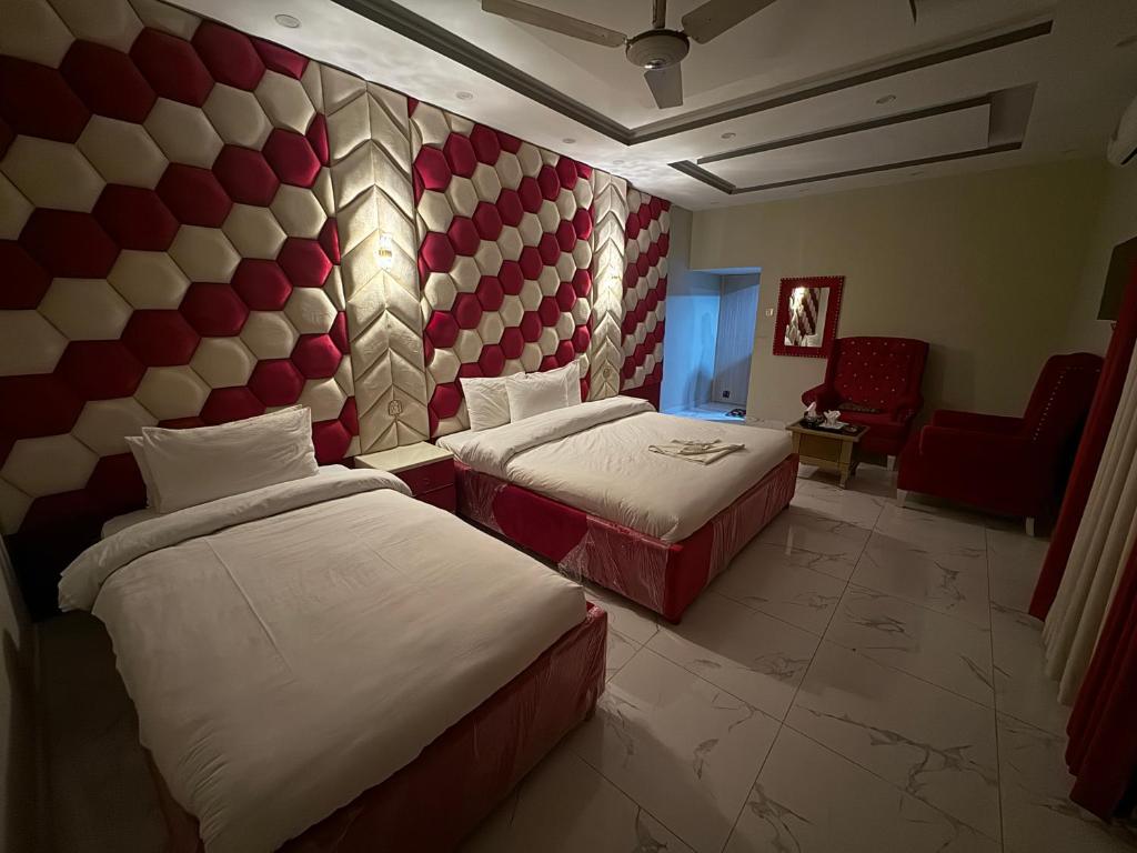 伊斯兰堡Decent Lodge Guest House F-10的酒店客房,配有两张床和椅子