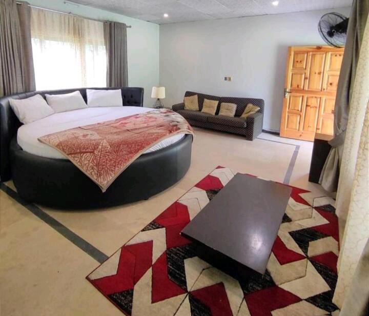 BālākotC O Z Y Hut At Country Club Balakot的一间卧室配有一张大床和一张沙发