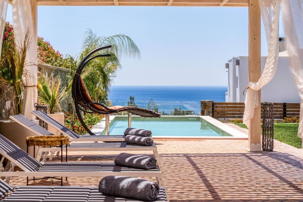 吉奥塔略Heliophos Villa Aelia的一个带躺椅的游泳池,享有海景