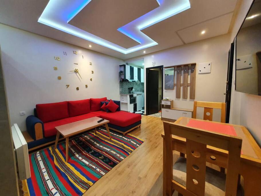 拉巴特DOUBLE Studio的客厅配有红色的沙发和天花板上的时钟