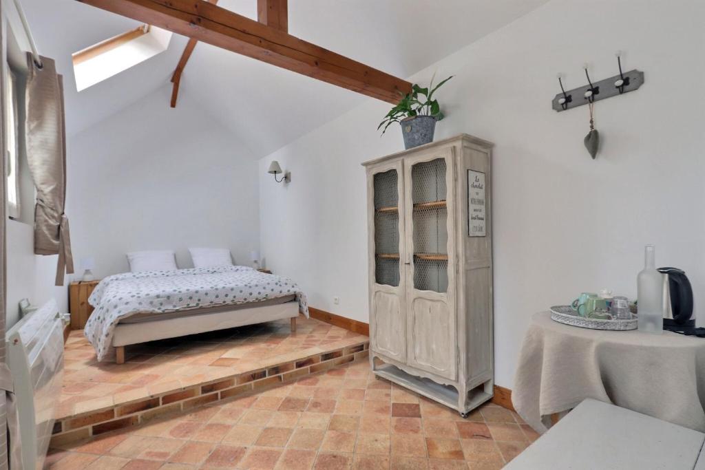 博韦Chambres Beauvais的一间卧室配有一张床、一个橱柜和一张桌子