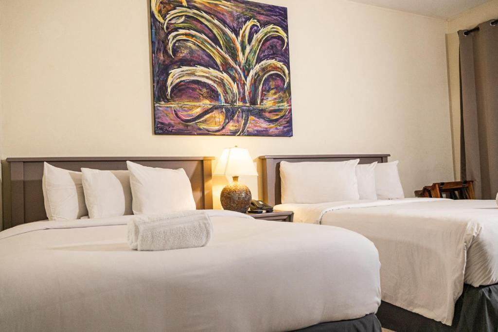 圣萨尔瓦多Morrison Hotel de la Escalon的两张位于酒店客房的床,墙上挂着一幅画