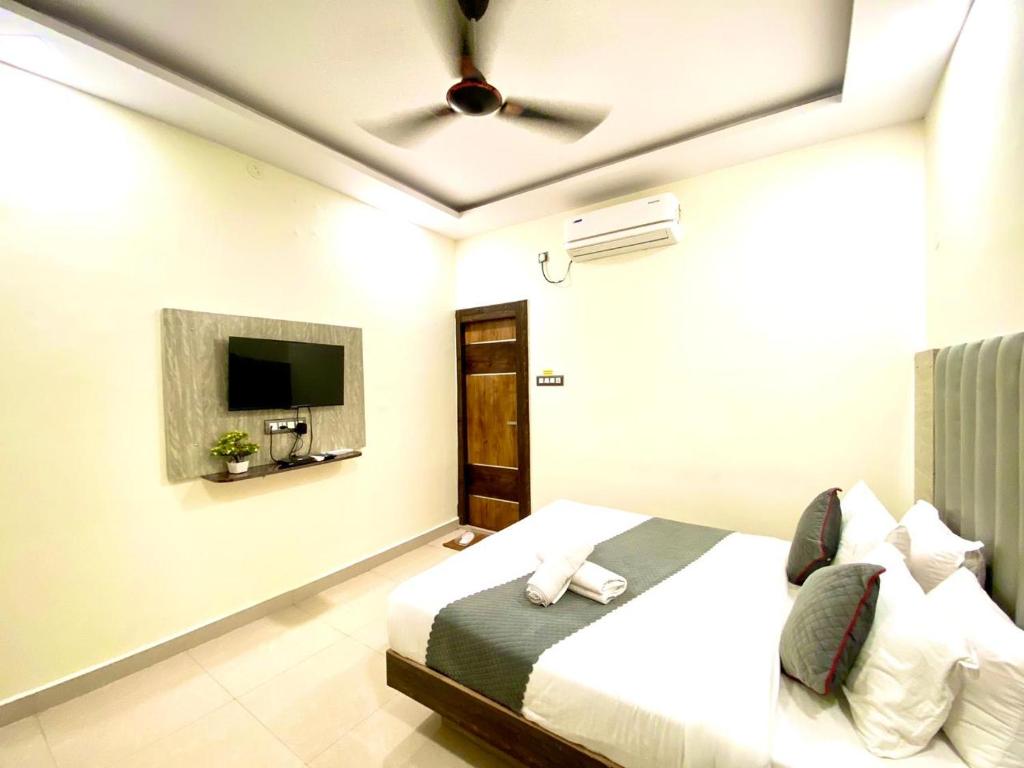 商沙巴Hotel Sky International- Airport Zone Hyderabad的一间卧室配有一张床和一台平面电视