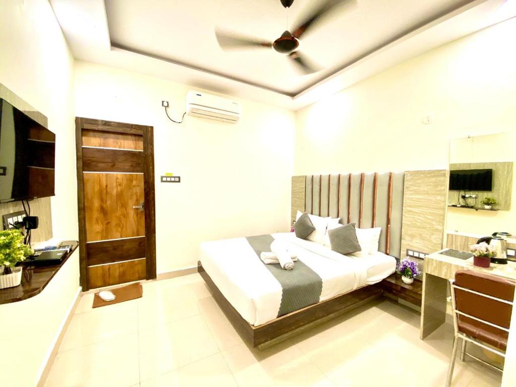 商沙巴Hotel Sky International- Airport Zone Hyderabad的一间卧室配有一张带吊扇的床
