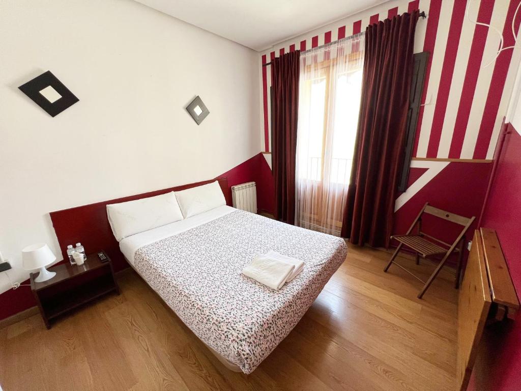 马德里广场之家旅馆的一间小卧室,配有一张床和一把椅子
