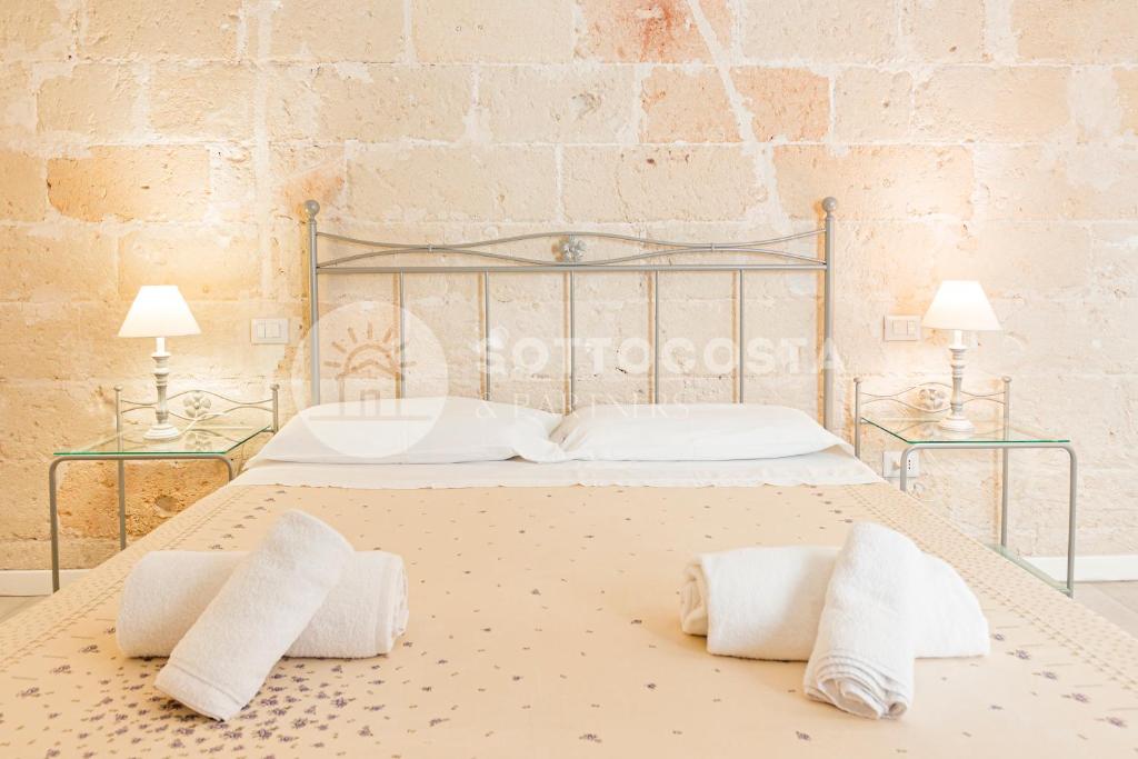 切萨雷奥港InCentro b&b的一间卧室配有一张带枕头的床和两盏灯。