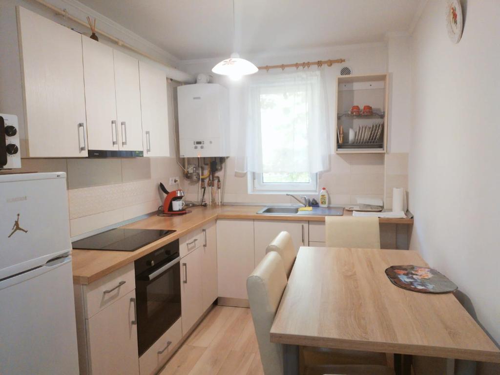 巴亚马雷Gold Apartments的厨房配有白色橱柜和木桌