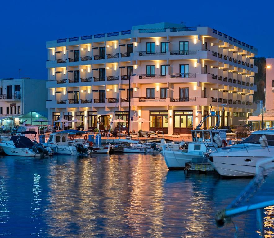 干尼亚Porto Veneziano Hotel的码头前有船停靠的建筑