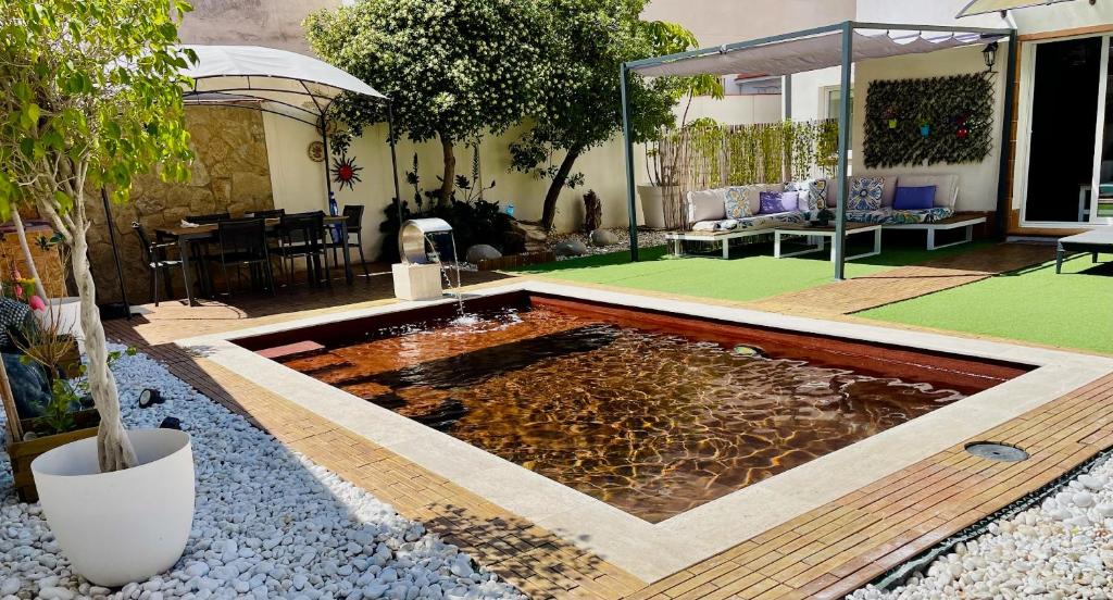 埃斯普卢加·德·隆布雷格Villa Paradise, urban oasis by -Toprentalsbarcelona-的庭院中间的一个池塘,庭院中有一个庭院