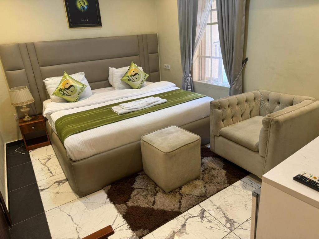 伊凯贾Sugarland Hotel and Suite的一间卧室配有一张大床和一张沙发
