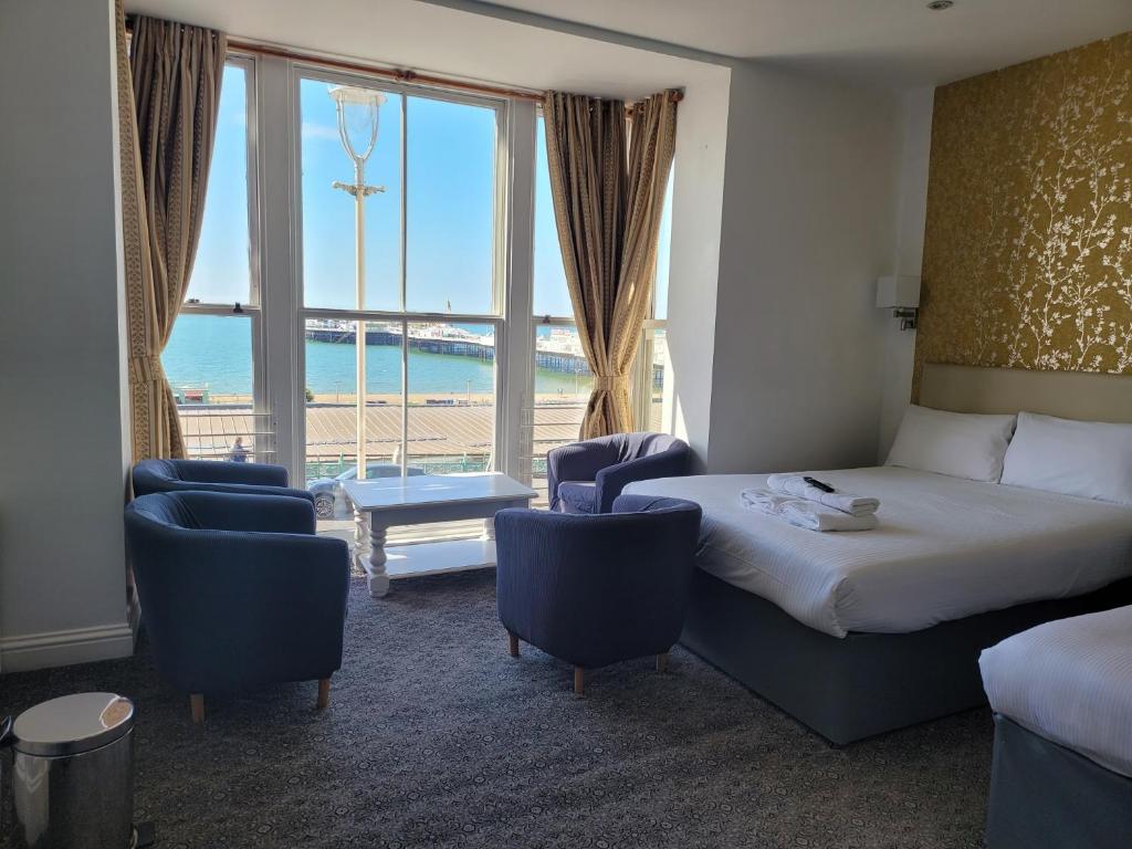 布莱顿霍夫大西洋海滨酒店的酒店客房设有床、椅子和大窗户。