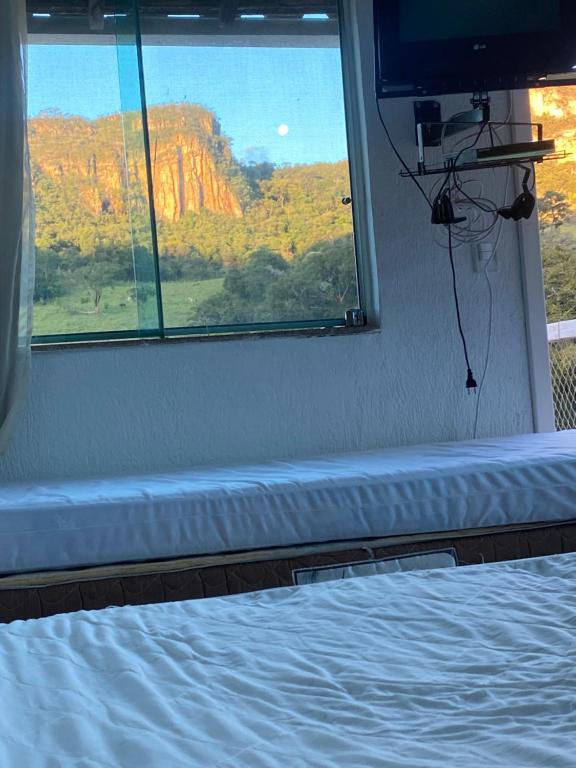 瓜佩Paraiso na beira de cachoeiras Canyons Capitólio MG的一间卧室设有一张床和一个美景窗户。