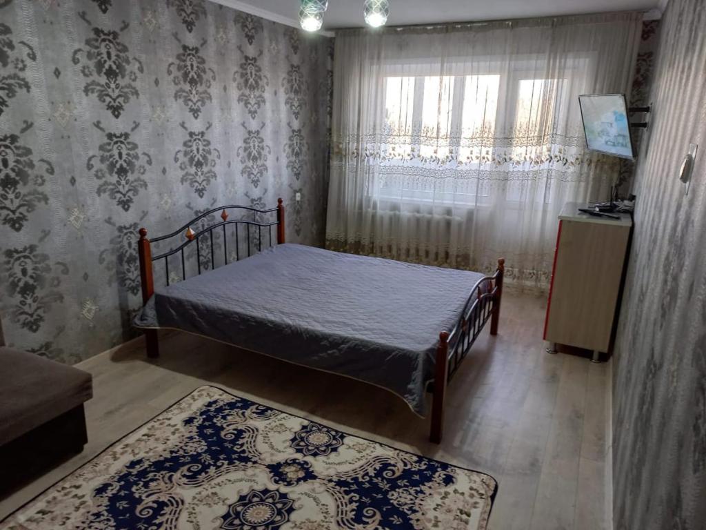 卡拉甘达Комфортные аппартаменты的一间小卧室,配有床和窗户