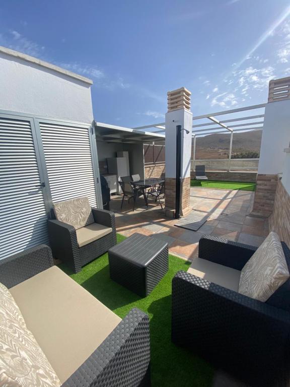 加尔达尔Ático Playa Sardina的房屋内一个带沙发和椅子的庭院