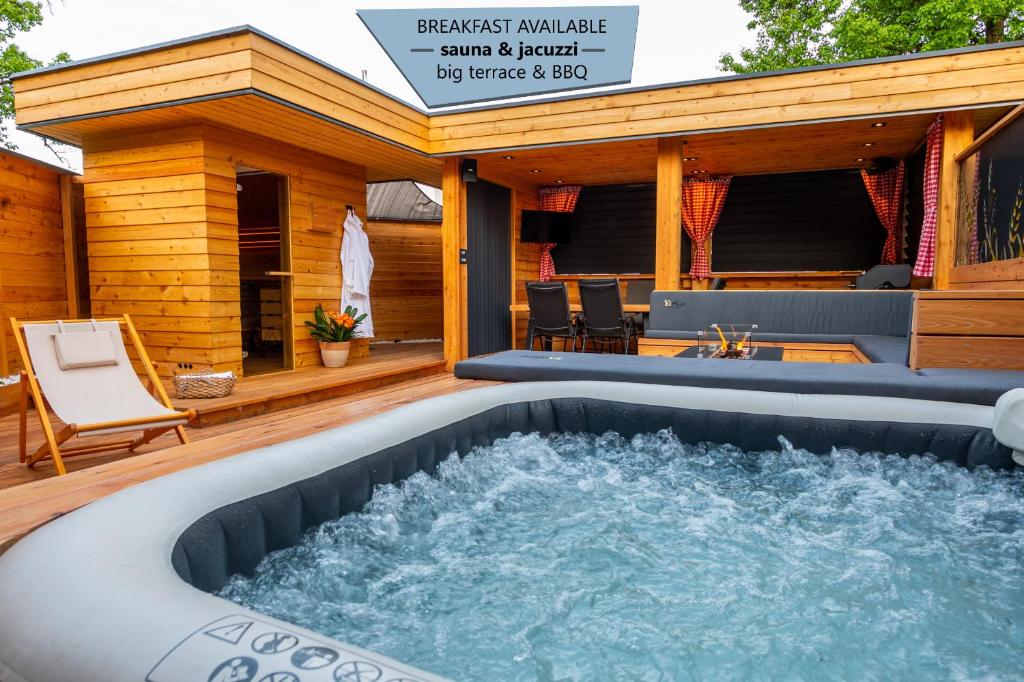 莫济列House "HISCA" With Private Terrace, BBQ, Fireplace, Sauna, Hot Tub的房屋甲板上的热水浴池