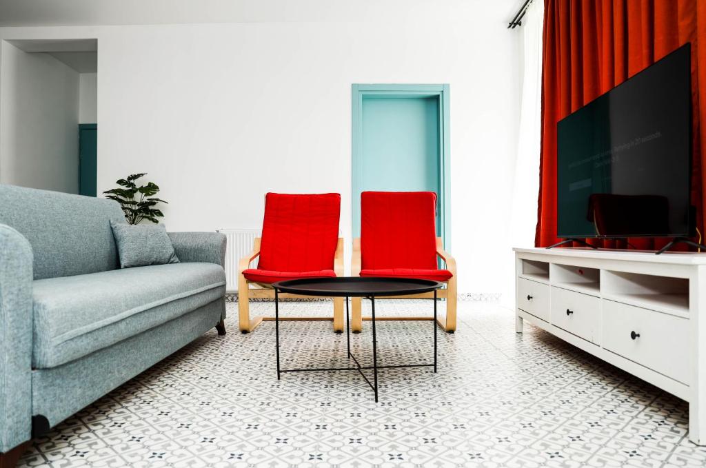 谢赫维蒂利Villa Capri-Kaprovani的客厅配有2把红色椅子和电视