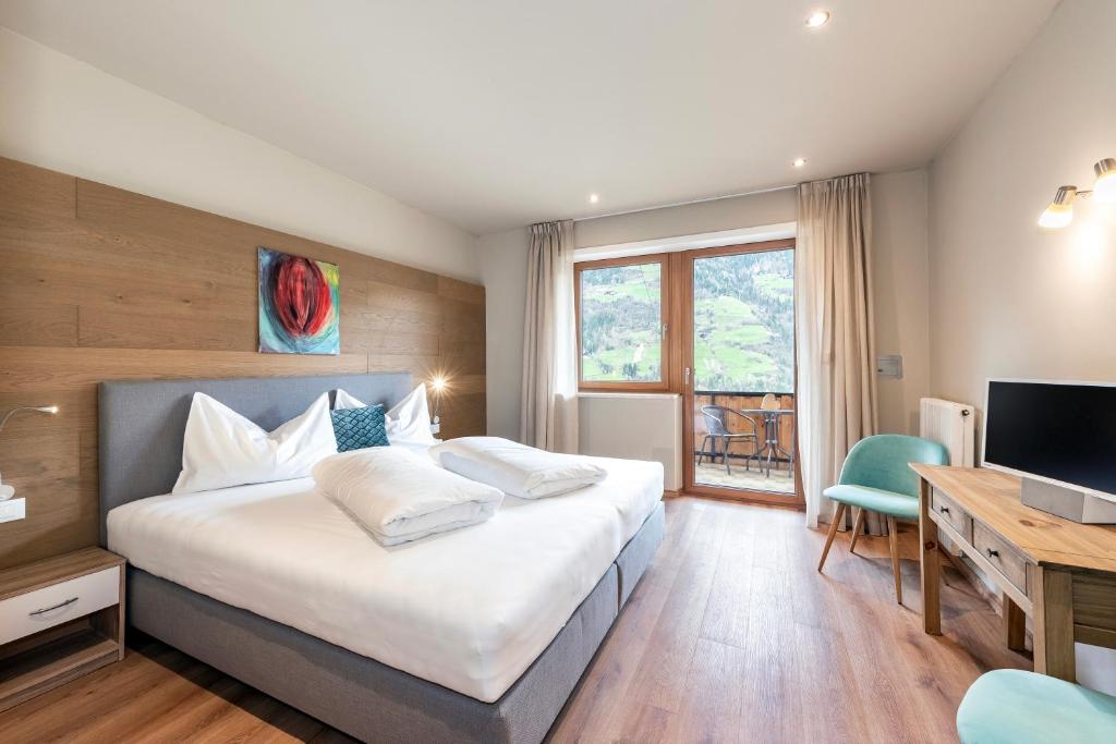 萨尔图西奥圣乌尔苏拉酒店的一间卧室配有一张床、一张书桌和一台电视
