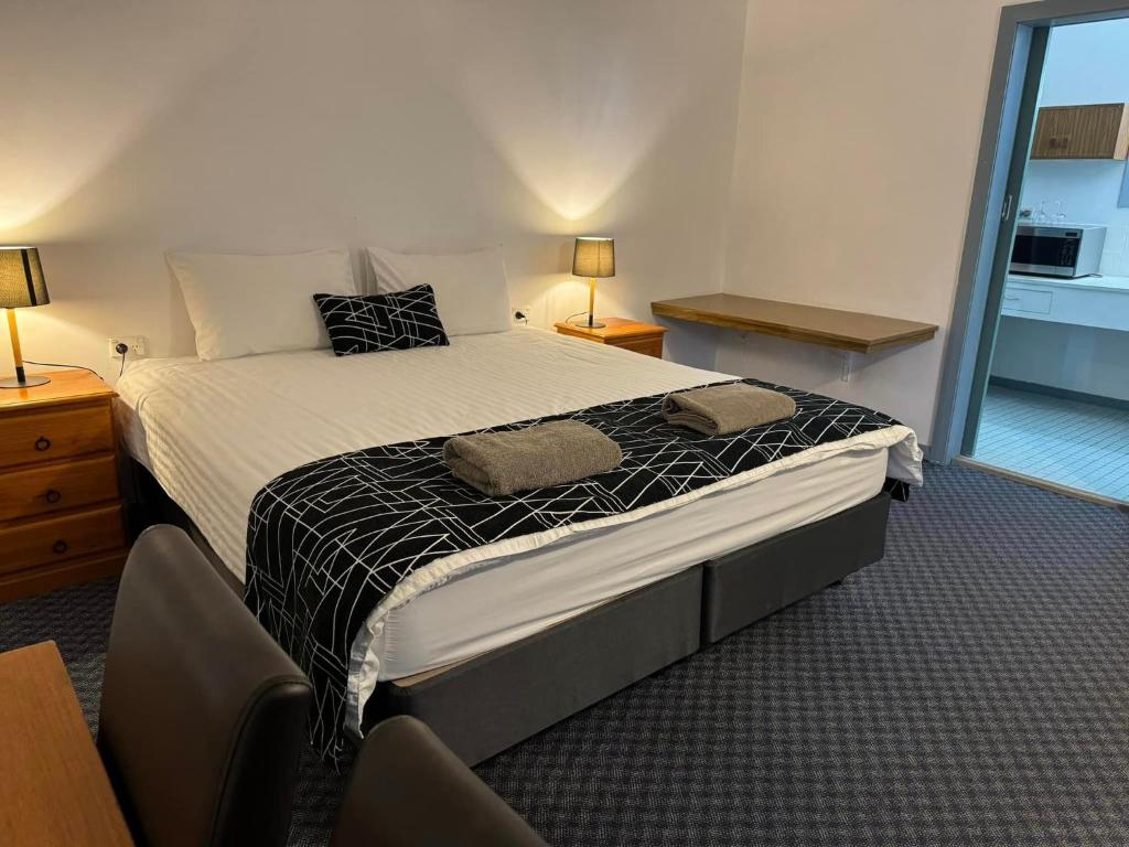 拜恩斯代尔Castle Motel Bairnsdale的一间卧室配有一张床,上面有两条毛巾