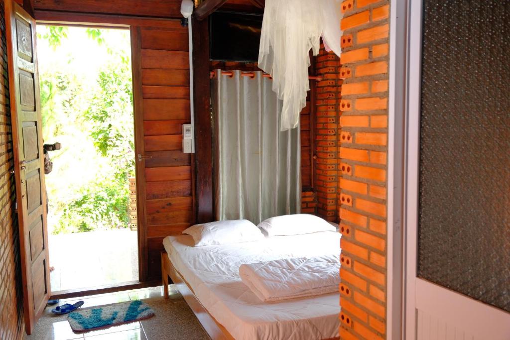 Tân PhúDu Nam Riverside Tour Trọn Gói的一间带床的卧室,位于带窗户的房间内