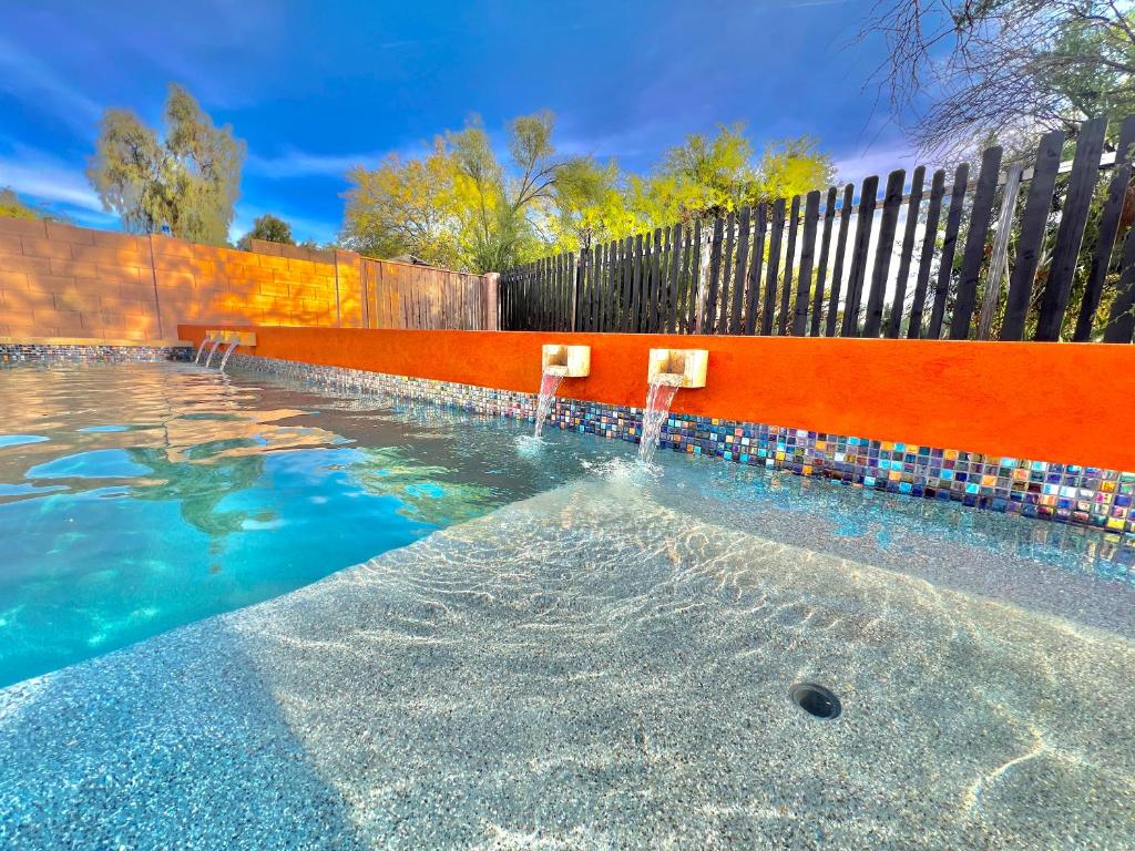 喷泉山Stylish Fountain Hills gem with game room的蓝色海水游泳池和围栏