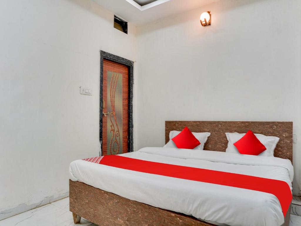 博帕尔OYO Hotel Shivansh的一间卧室配有一张带红色枕头的大床