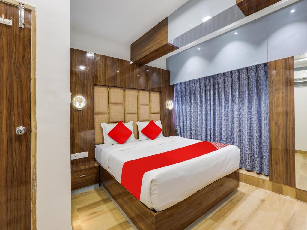 艾哈迈达巴德OYO Hotel bhanu Villa的一间卧室配有一张带红色枕头的大床