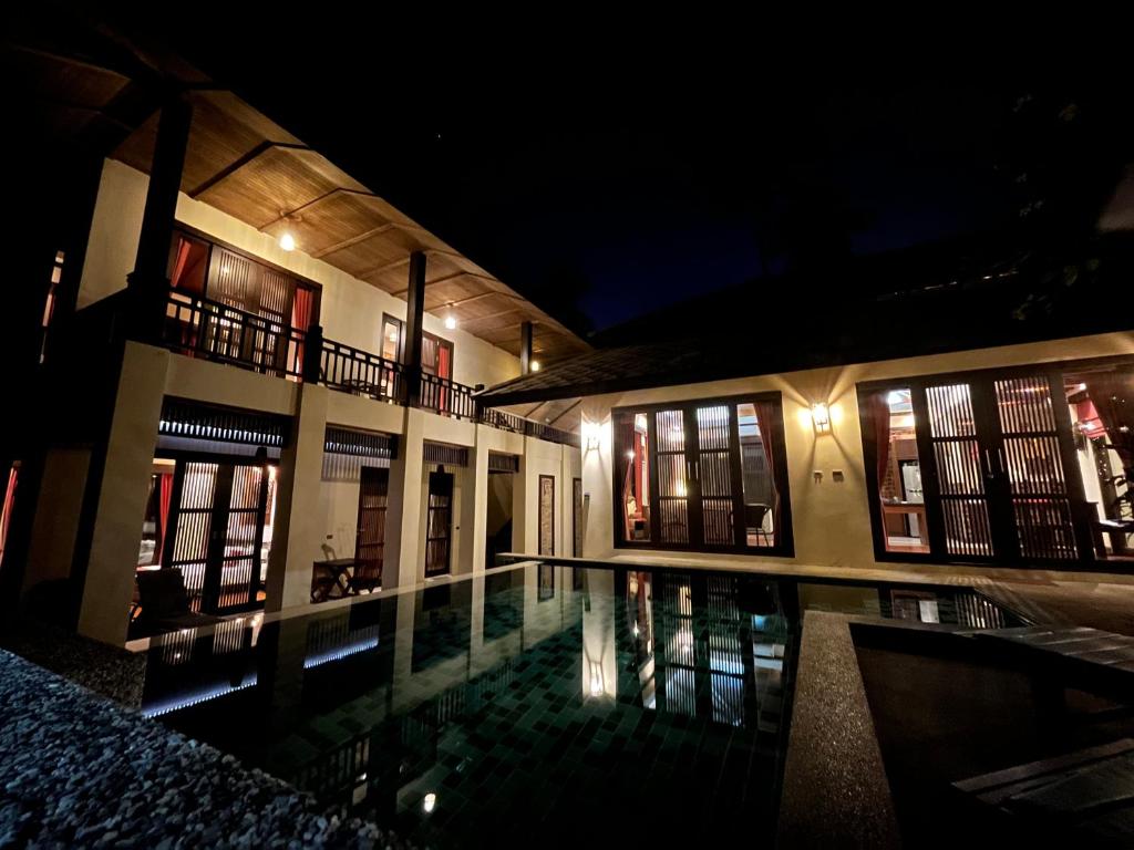 湄南海滩Large 4 bed villa short walk to Maenam beach的一座晚上设有游泳池的建筑