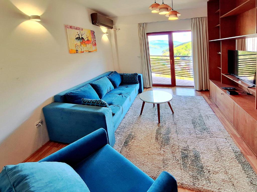 马夫罗沃Mavrovo Forest Apartments的客厅配有蓝色的沙发和桌子