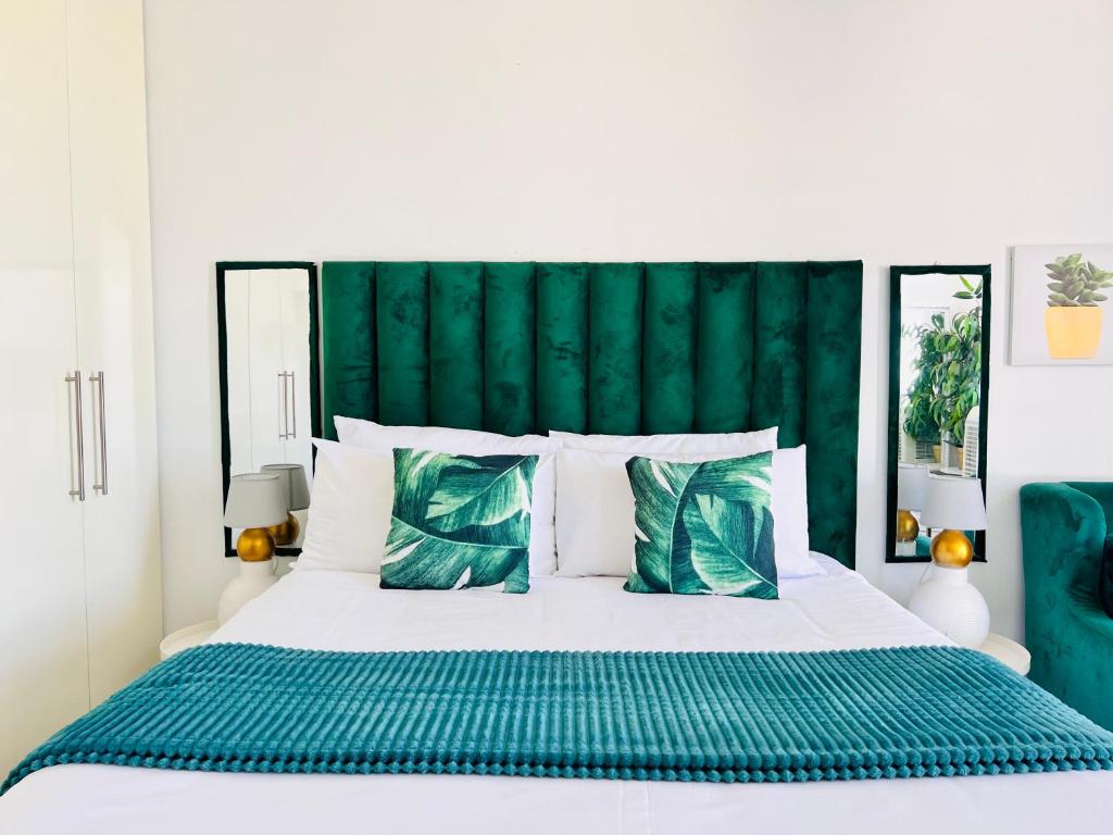 温特和克City junction studio apartment的一间卧室配有一张白色床和绿色床头板