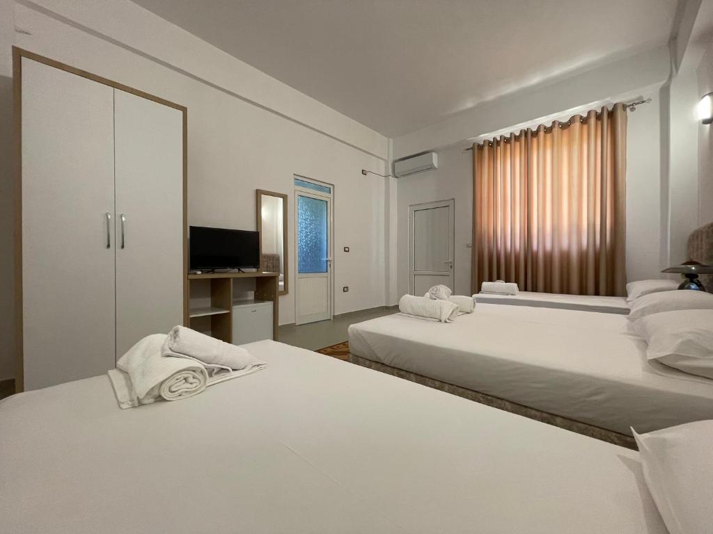 培拉特Villa Deart Berat的带电视的客房内的2张白色床