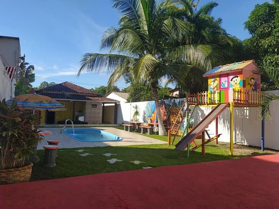 阿尔特杜尚Recanto das Palmeiras Alter do Chão的后院设有带滑梯和房屋的游乐场