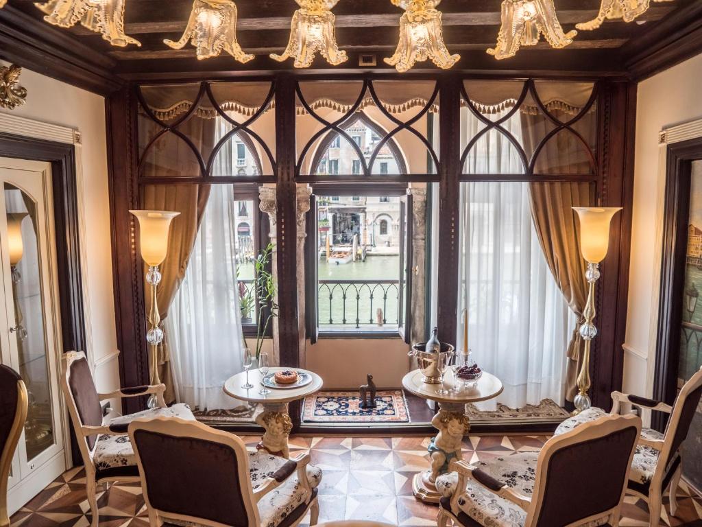 威尼斯EGO' Boutique Hotel - The Silk Road的客房设有带桌椅的大窗户。