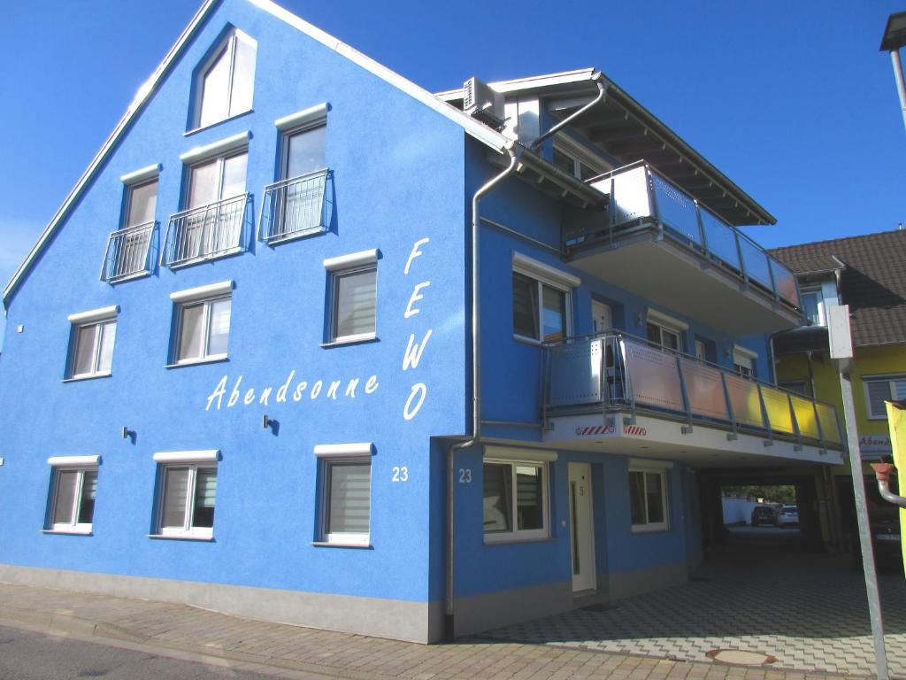鲁斯特Ferienwohnungen Abendsonne - 7 Gehminuten zum EP的蓝色的建筑,旁边标有标志