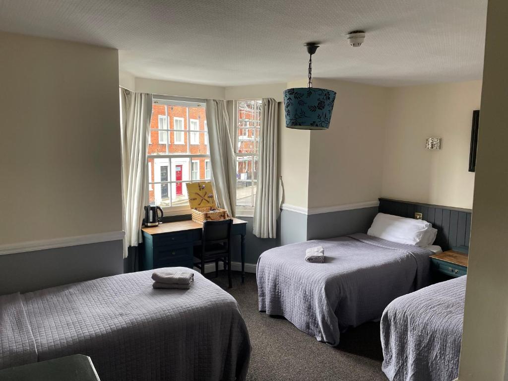 彻特西奥尔德天鹅酒店的客房设有两张床、一张桌子和一个窗户。