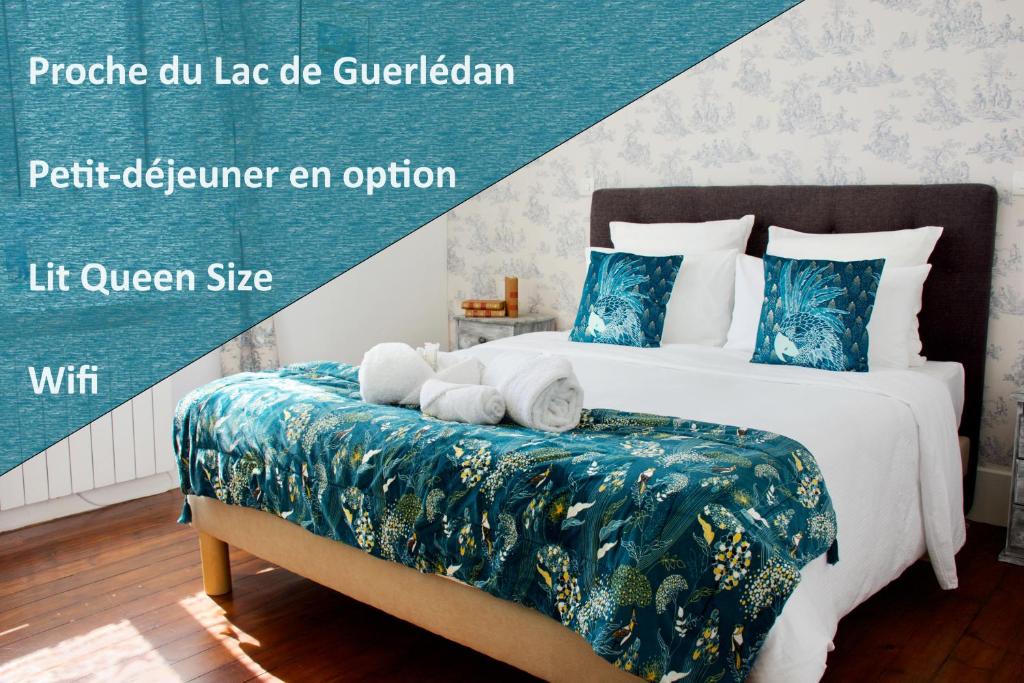 CaurelValfrescos - Lac de Guerlédan的一间卧室配有一张带蓝白色床单的大床
