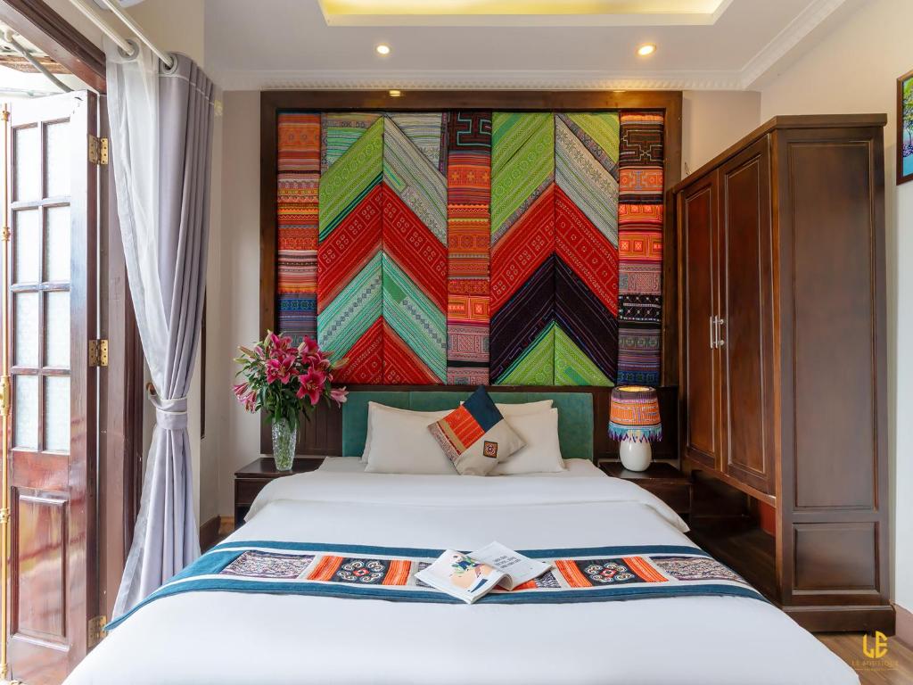 萨帕Le Boutique Sapa Hotel的一间卧室配有一张带彩色墙壁的床