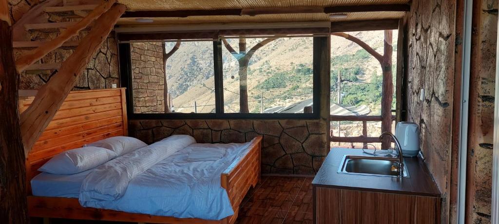 达纳达纳塔酒店的一间卧室配有一张带水槽和窗户的床