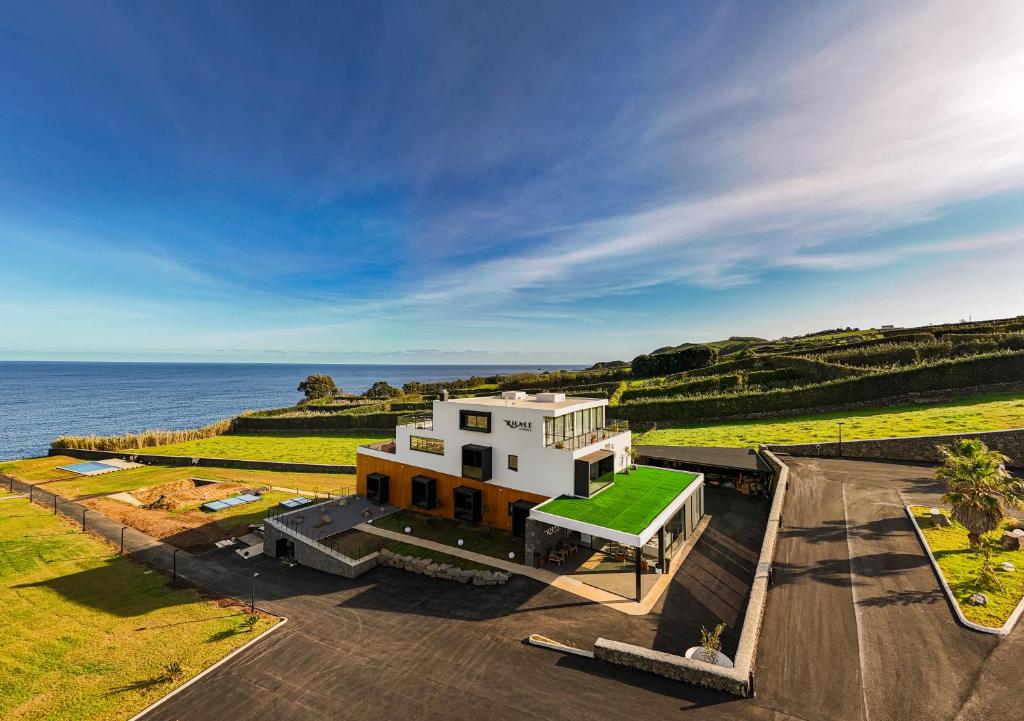 英雄港Xhale Azores的海边的白色房子,有绿色的屋顶