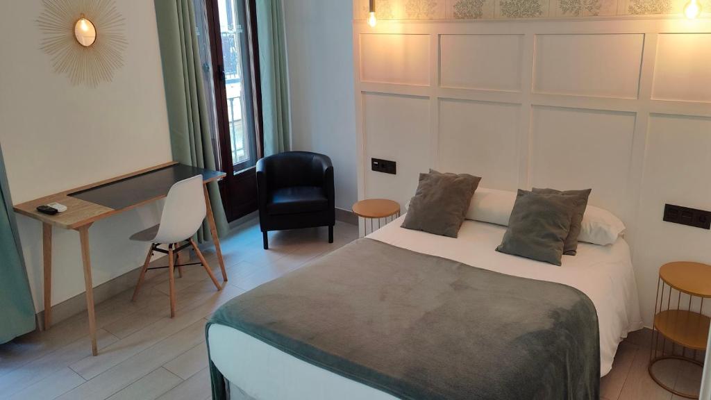 格拉纳达塞德兰酒店的一间卧室配有一张床、一张桌子和一把椅子