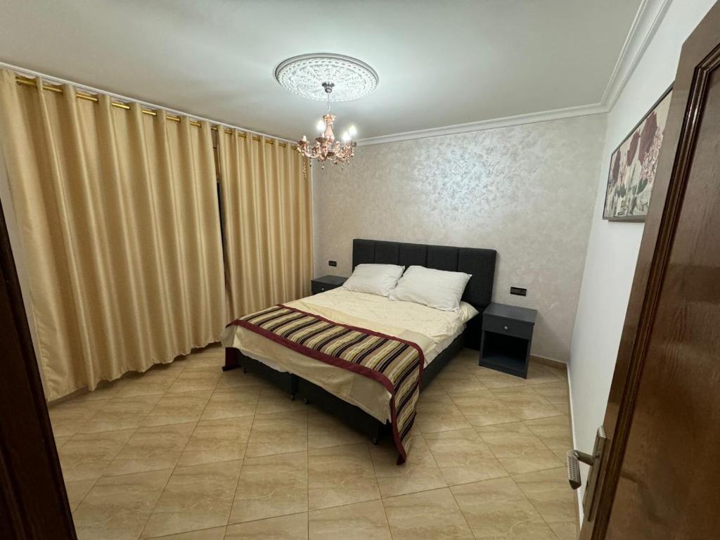 纳祖尔Appart Hotel Excellent的一间卧室配有一张床和一个吊灯