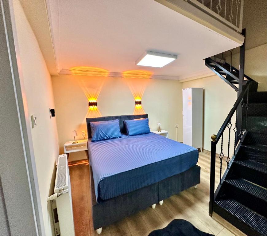 伊斯坦布尔Golden Stay Boutique Hotel Taksim的一间卧室配有一张带蓝色枕头的床,并设有一个楼梯