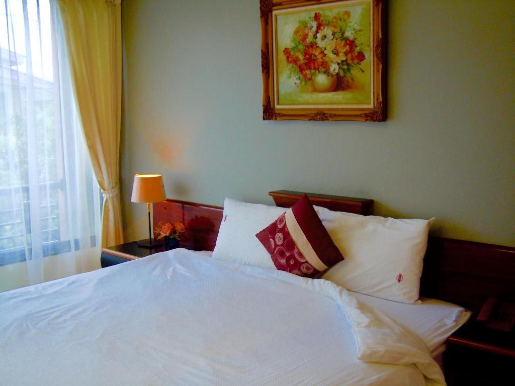 呵叻月光之家公寓式酒店的一间卧室配有带白色床单和枕头的床。