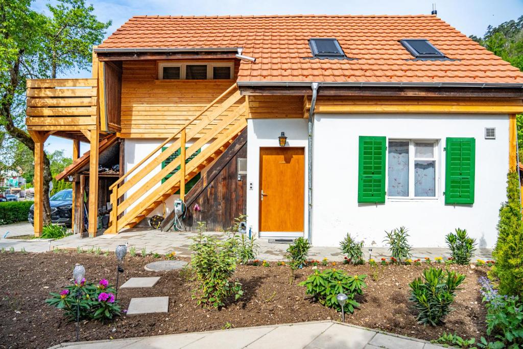 LengnauGemütliches Haus mit Terasse und Feuerstelle的一座带橙色屋顶和绿色百叶窗的房子