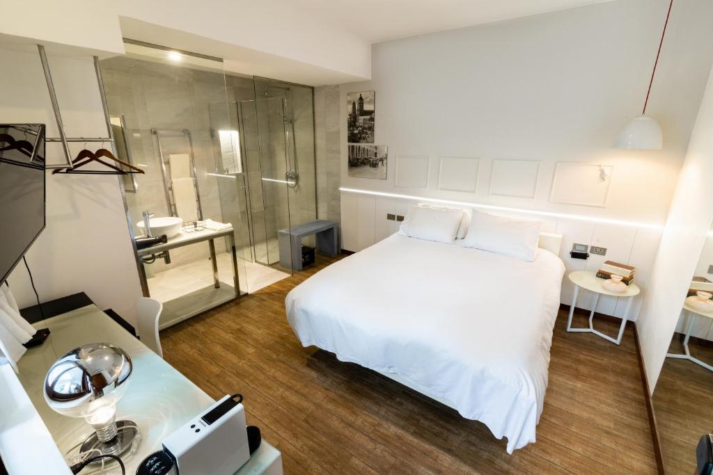 圣克鲁斯Cosmopolitano Hotel Boutique的卧室配有白色的床和淋浴